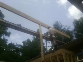 Carpenter setting a ridge beam over a new addition frame — Ice Dam Removal by Roofing Brothers in Ovid