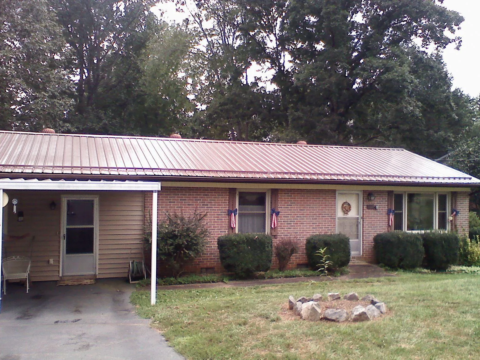 Bronze metal roof and carport on a brick ranch home — Roof Repair work by our crew in Ovid